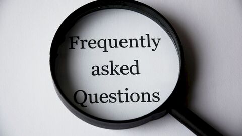 FAQ Eine Lupe, die die Wörter Frequently asked Question zeigt