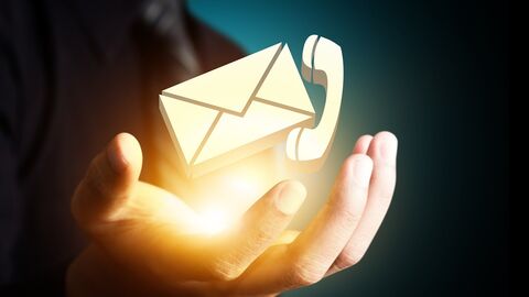 Hand über der die Symbole Briefumschlag und Telefonhörer schweben