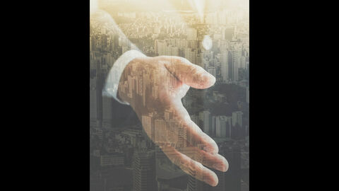 Gemeindefusion Halbtransparente Hand vor einer Stadt
